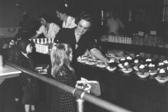 Lunch-Worker-handing-child-a-dessert-1942