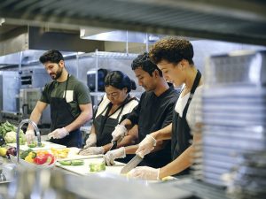 Photo of kitchen staff preparing food on the line.