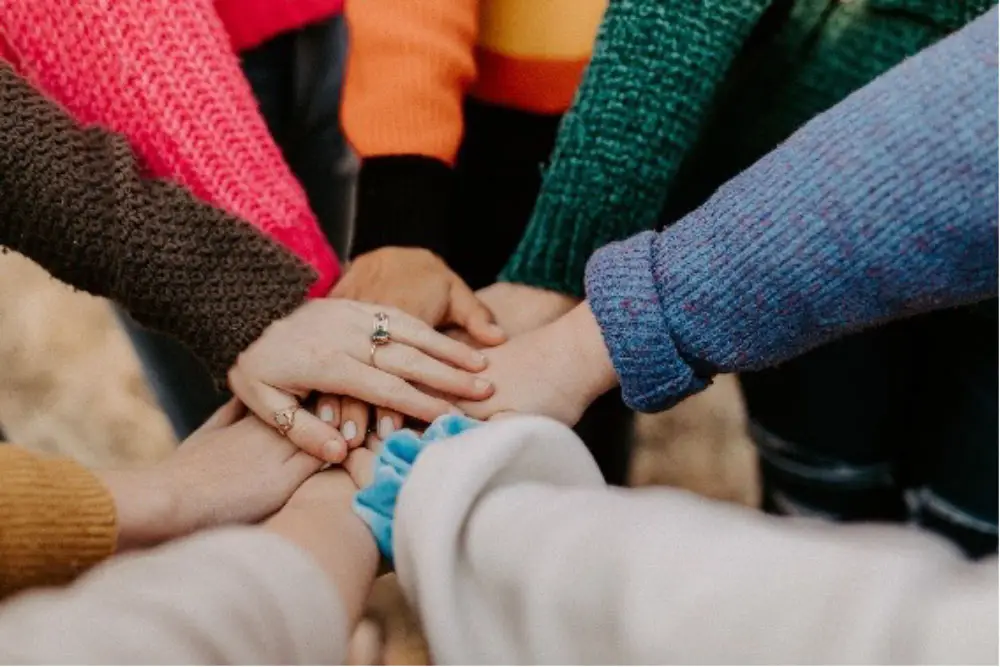 Photo of a group of hands in a huddle stacked on one another