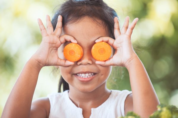 Asian child girl having fun to learn about vegetables with happiness