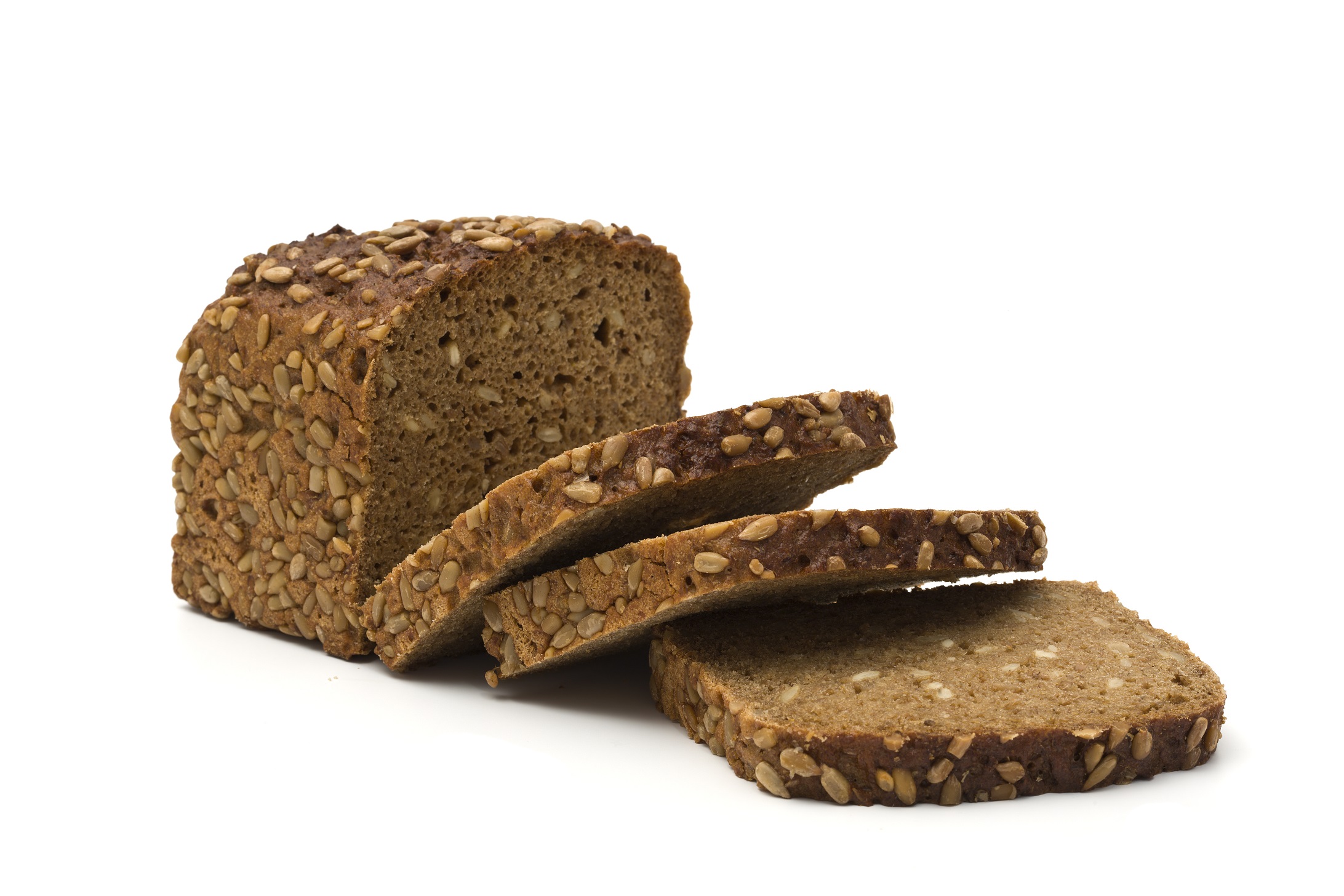 whole grain brown bread, three slices in front of half loaf, isolated on white