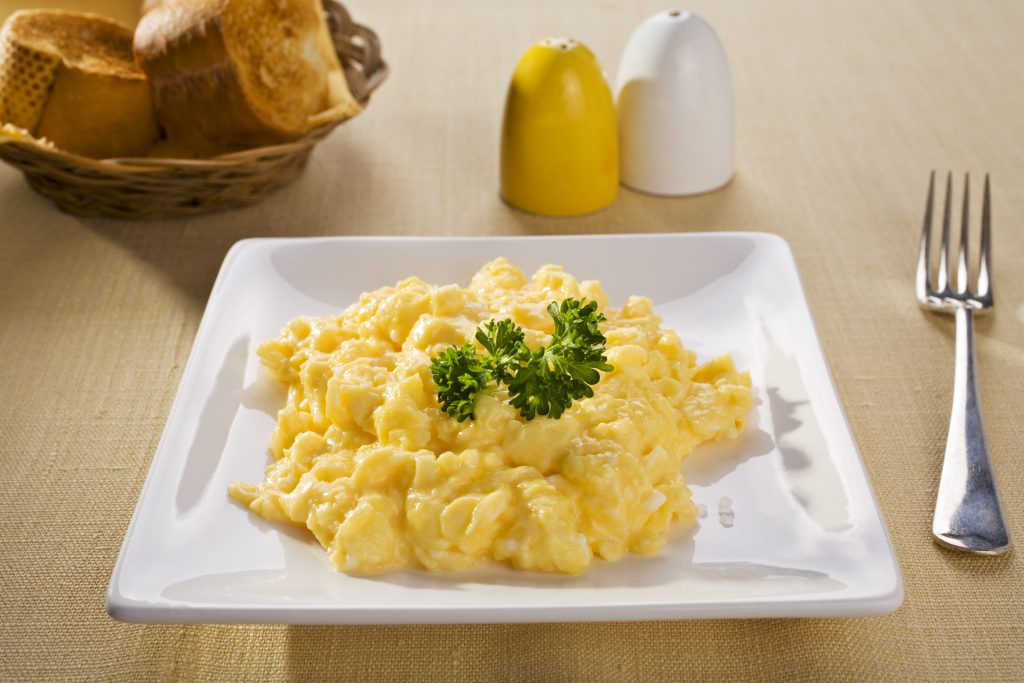 "Scrambled eggs on a white plate, and toasted baguette in the background. More breakfasts:-"